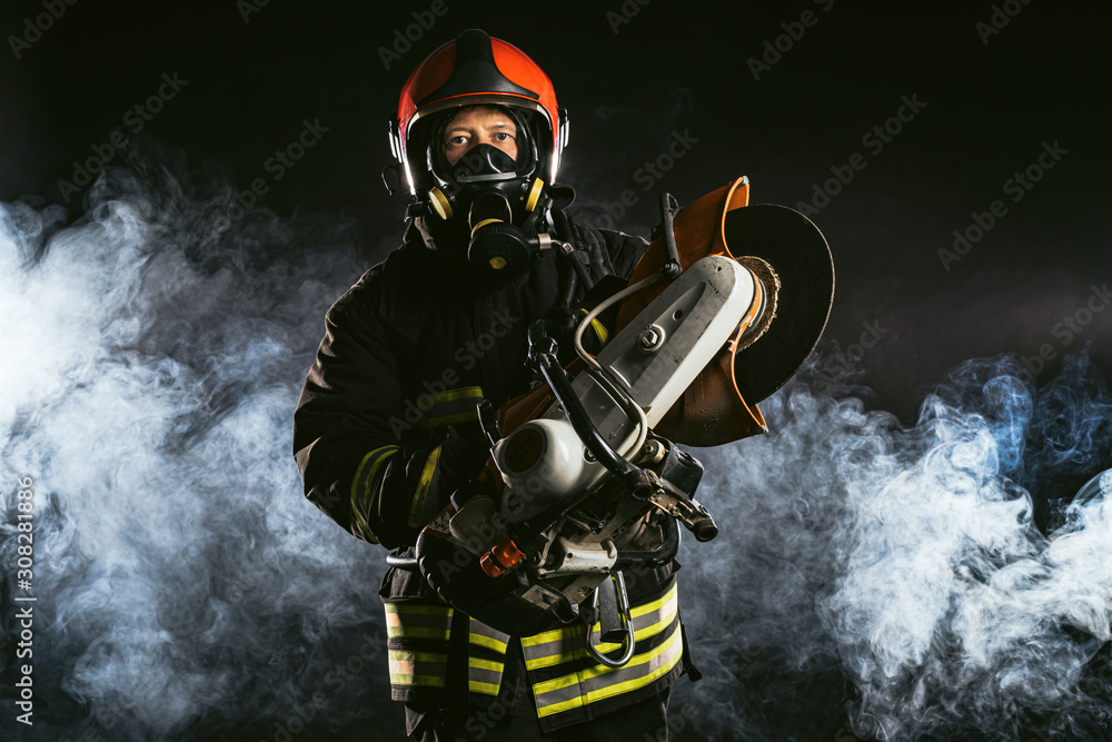Obraz premium fireman or firefighter stand in smoke, professional worker of fire station in uniform, in helmet