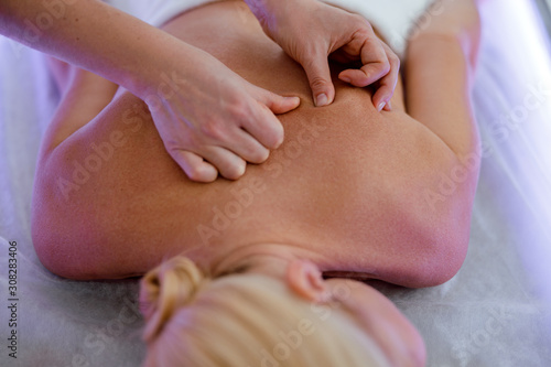 Top view of masseur hands doing back massage in spa salon