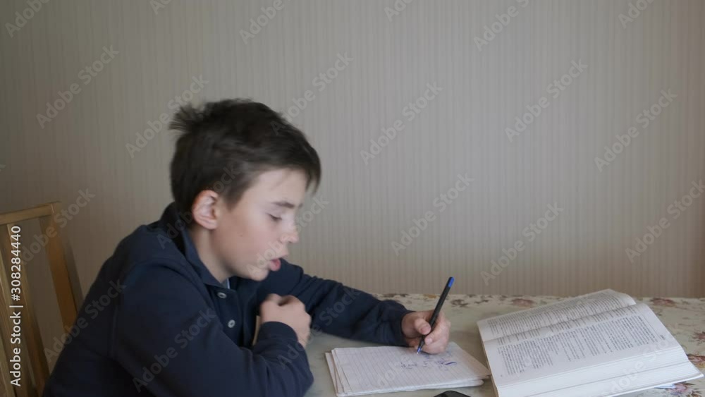 the boy performs homework, preparing for school. the boy performs homework, preparing for school.