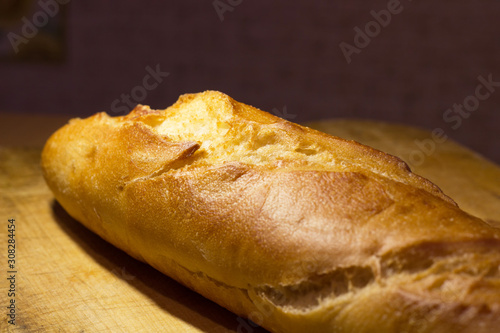 fresh crispy baguette lies on a wooden board