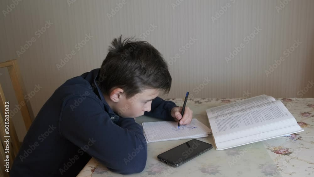 the boy performs homework, preparing for school. the boy performs homework, preparing for school.