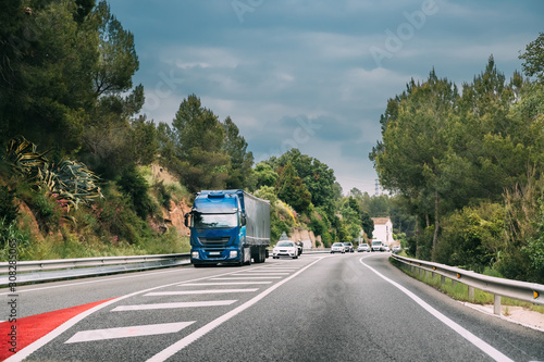 Truck Or Traction Unit In Motion On Road, Freeway. Asphalt Motorway Highway Against Background Of Forest Landscape. Business Transportation And Trucking Industry
