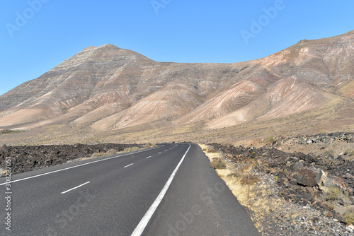Scenic road, mountains and volcanic landscape in Timanfaya National Park, Lanzarote, Canary Islands, Spain 