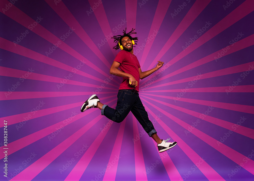 Obraz premium Boy with yellow headset listens to music and dances. emotional and energetic expression.