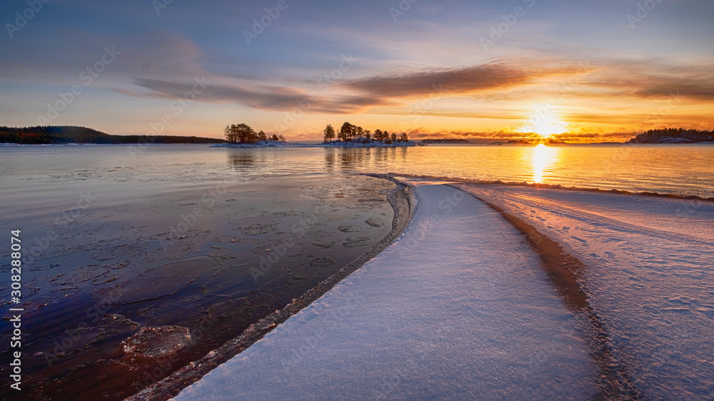 The first ice  off the coast on the water in Lake Ladoga at dawn with fresh snow in winter