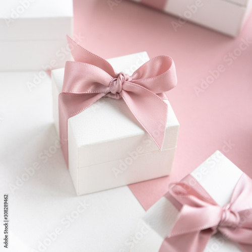 Gift boxes wiyh powdery ribbon. Powdery background. Silver bracelet with charms. Gift box for the New Year and Christmas. Best gift for Valentines Day and Mothers day.