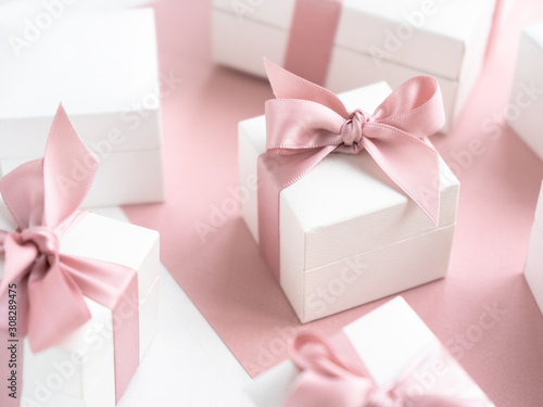 Gift boxes wiyh powdery ribbon. Powdery background. Silver bracelet with charms. Gift box for the New Year and Christmas. Best gift for Valentines Day and Mothers day.