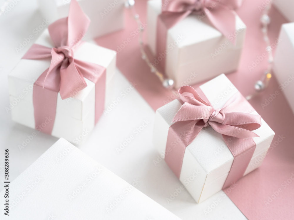 Obraz premium Gift boxes wiyh powdery ribbon. Powdery background. Silver bracelet with charms. Gift box for the New Year and Christmas. Best gift for Valentines Day and Mothers day.
