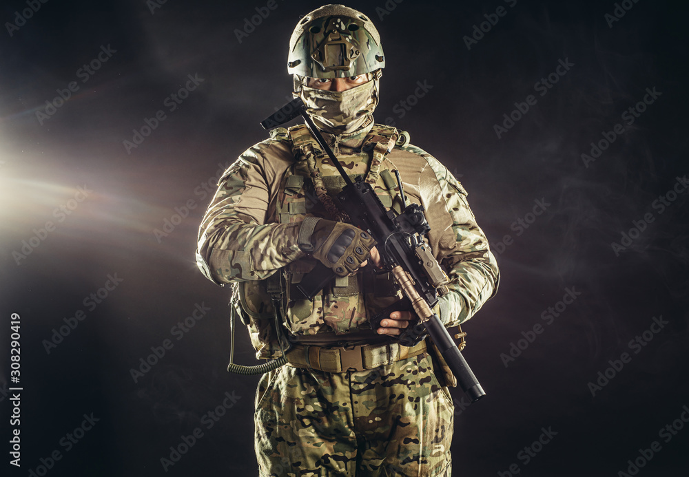 Fototapeta premium young caucasian military man in camouflage protect people from war, protect his country. brave soldier look at camera isolated in studio
