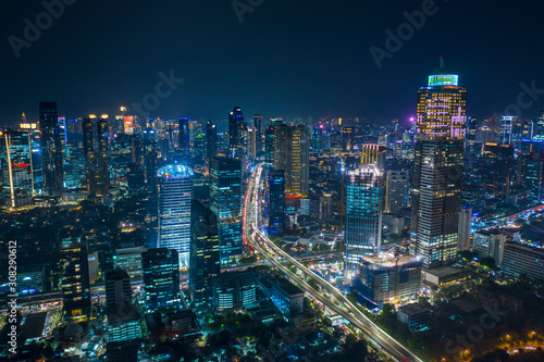 Aerial view of glowing skyscrapers beside highways