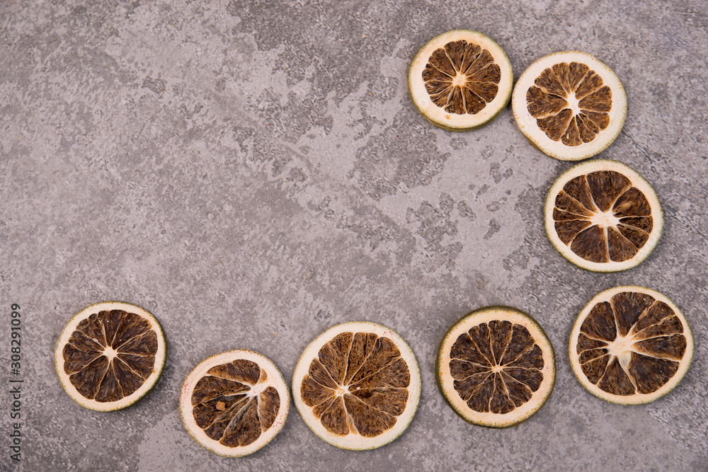 Dried oranges and lemons on a grey structured background 