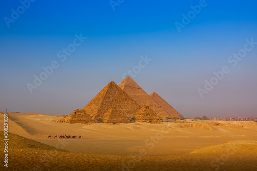 scenic panorama view of giza pyramids cairo egypt  with caravan 