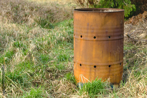 Rusty oil drum abandoned in a field isolated 