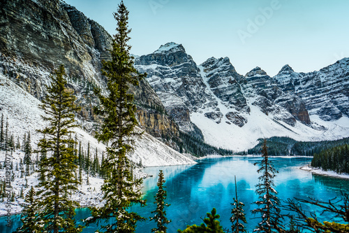 Moraine lake panorama in winter with frozen water and snow covered mountains, Banff National Park, Alberta, Canada