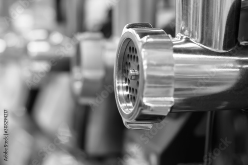 Metal shiny tube of an electric meat grinder. Side view. Black and white shot.