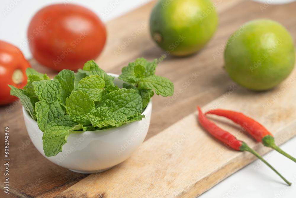 peppermint in small cup on board and Vegetable with white background peppermint in small cup on board and Vegetable with white background