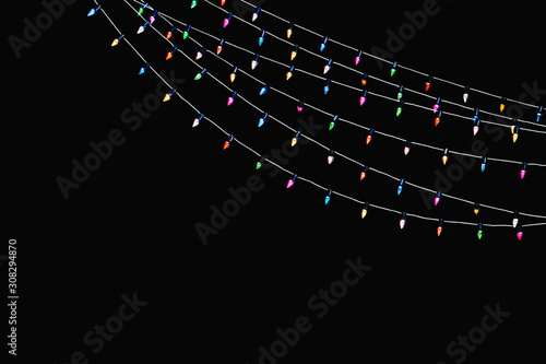 Happy holidays. Holiday garlands of colorful light bulbs isolated on a black, christmas background, xmas