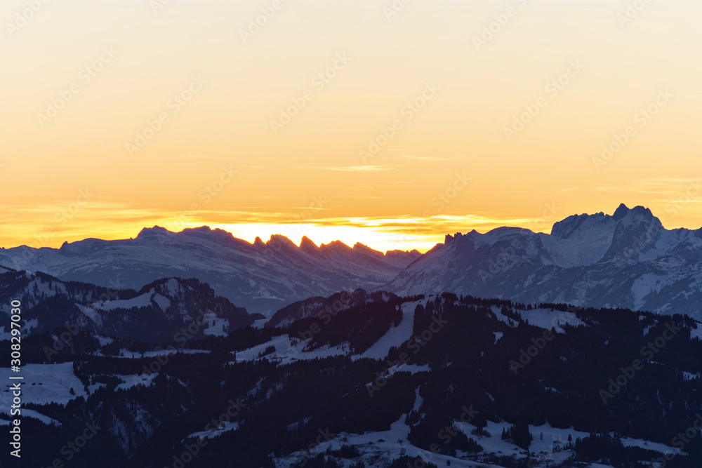 Colorful sunset at the Churfirsten mountains (Appenzell Alps, Switzerland). Alpine landscape with rocky mountains in winter. Copy space