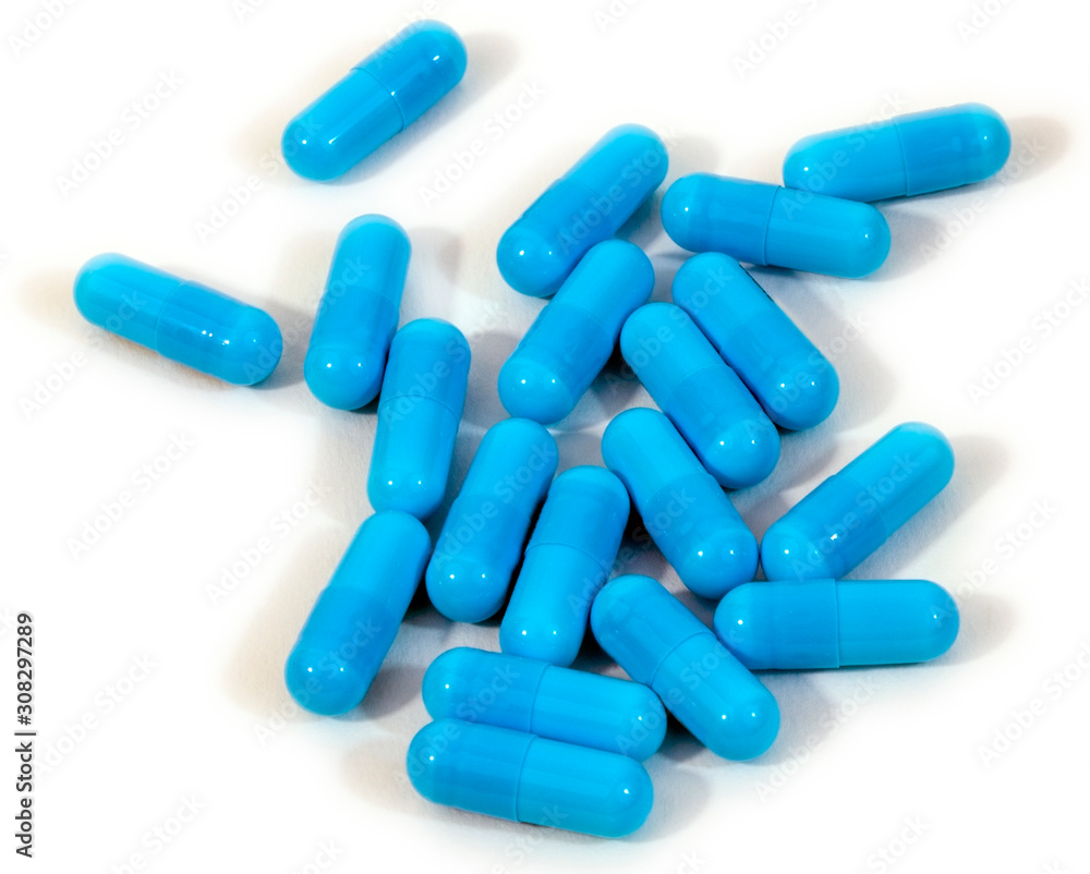 Blue medicine capsules scattered on a white background. Blue medicine capsules scattered on a white background.