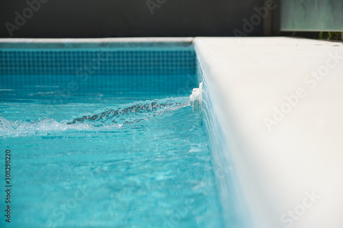 spout pouring water into a pool with crystal clear water
