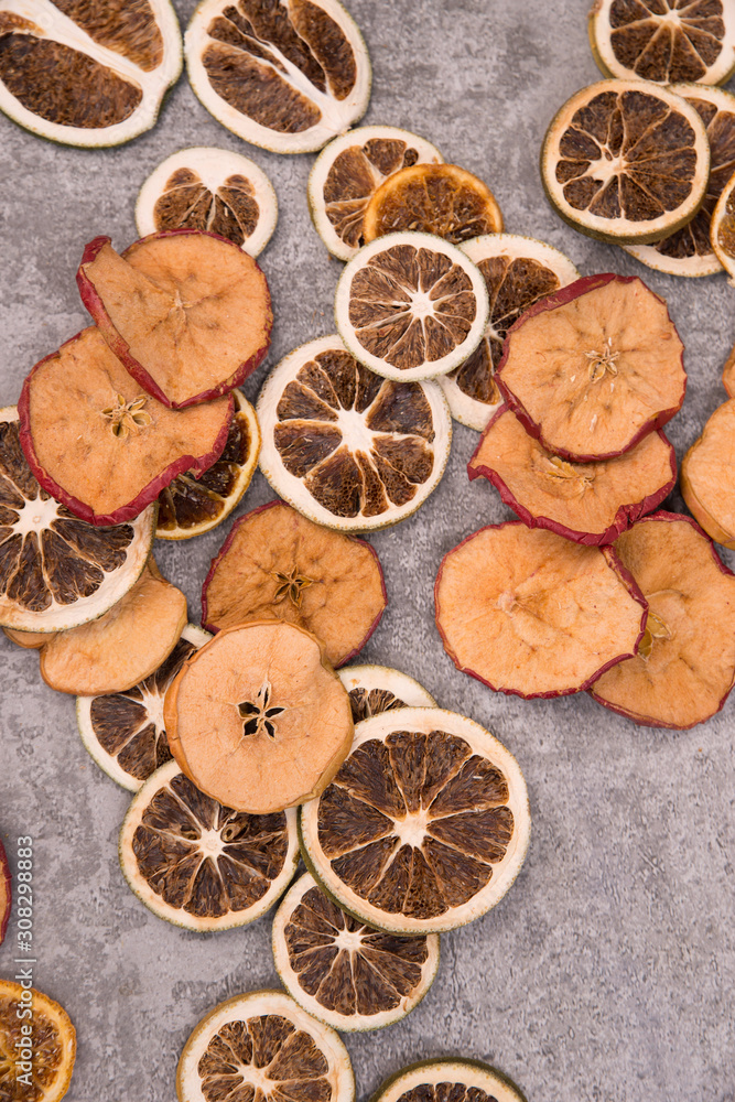 Dried lemon, orange and apple slices on a grey structured background Dried lemon, orange and apple slices on a grey structured background