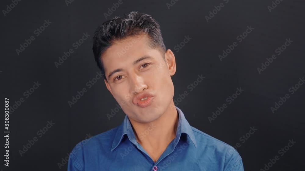 Young man in blue shirt doing weird facial expression
Young man in blue shirt doing weird facial expression