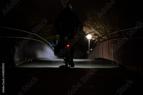 bicyclist on small bridge at night