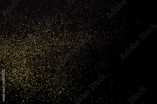 Christmas Gold glitter on black background. Holiday abstract texture