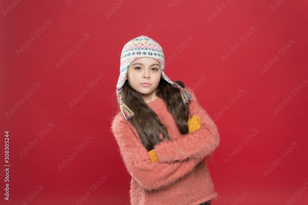 Wintertime concept. Little kid wear knitted hat. Little girl winter fashion accessory. Frosty weather. Winter outfit. Cute model enjoy winter style. Small child long hair wear hat red background Wintertime concept. Little kid wear knitted hat. Little girl winter fashion accessory. Frosty weather. Winter outfit. Cute model enjoy winter style. Small child long hair wear hat red background
