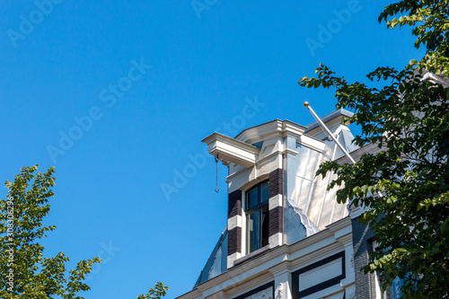 Photography Classic old house facade with blue sky in Amsterdam