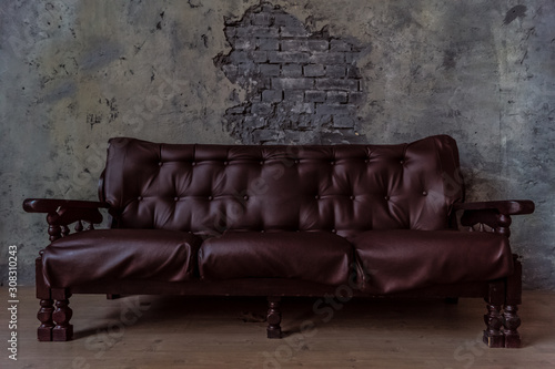 Luxurious leather, brown sofa, grey wall. classic vintage furniture.