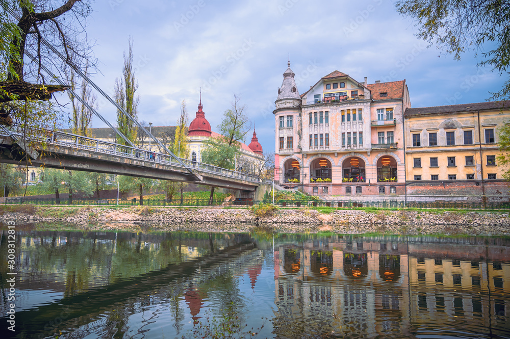 Landscape of Oradea City in Romania. River that crosses the city and in the background old buildings and a bridge over the river.