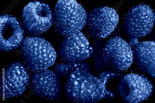 Classic Blue. Color of the Year 2020. scattering of raspberry berries on a black background