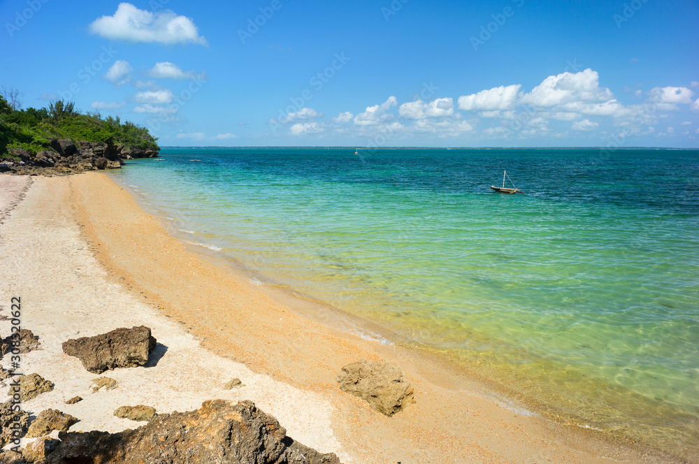 view to beach and bay with alone boat in water on Zanzibar island in Tanzania