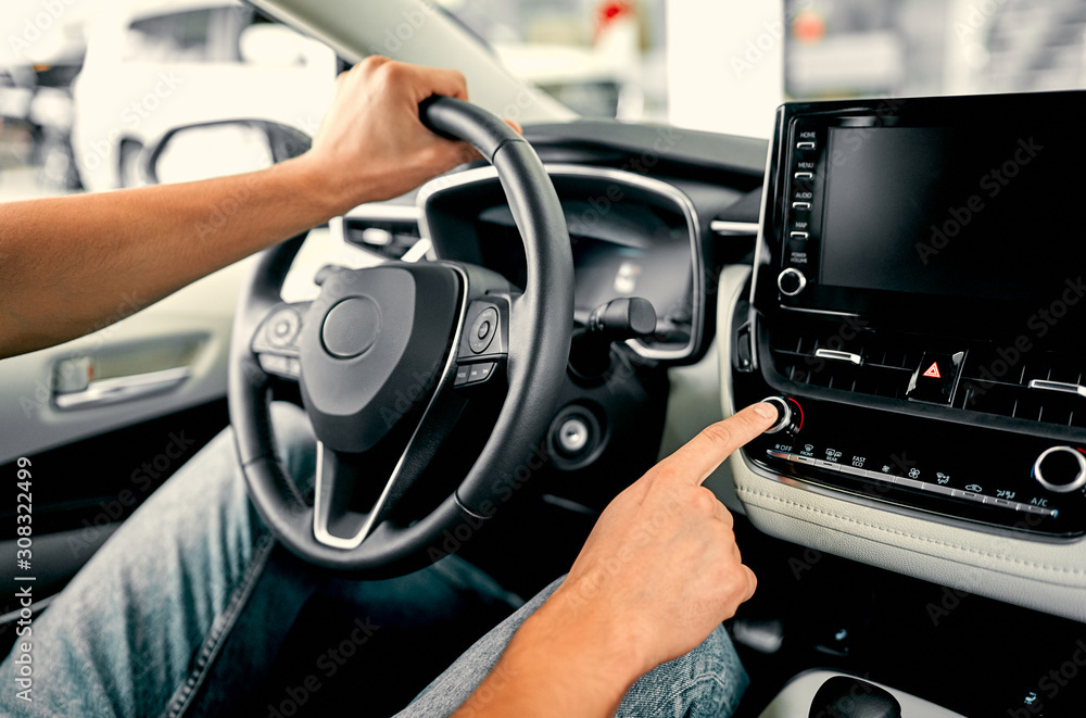 Obraz premium Cropped image hand of man using navigation system or dashboard while driving a car.