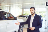 A car dealer shows a auto in a showroom. Auto business.