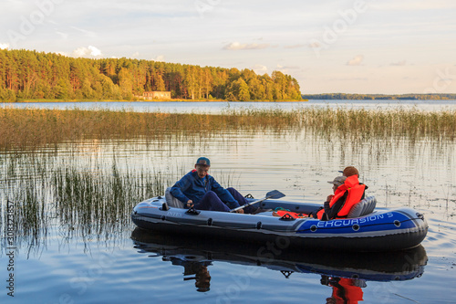 Dad son and daughter swim in inflatable boat on lake. inflatable boat. Lake Valdayskoye, Lake Valdai is freshwater lake, located in Valdaysky District of Novgorod Oblast in Russia photo