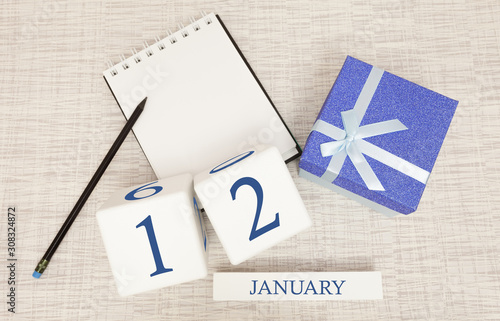 Calendar with trendy blue text and numbers for January 12 and a gift in a box.