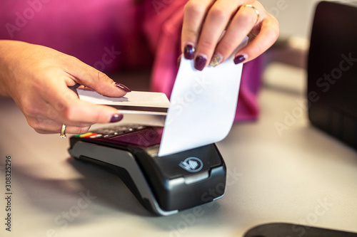 Close-up of hand use the credit card strip machine to pay.