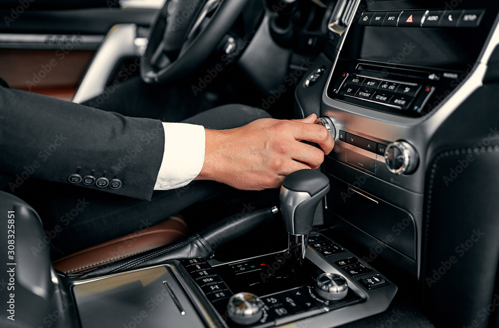 Transportation and vehicle concept - man using car audio stereo system Transportation and vehicle concept - man using car audio stereo system