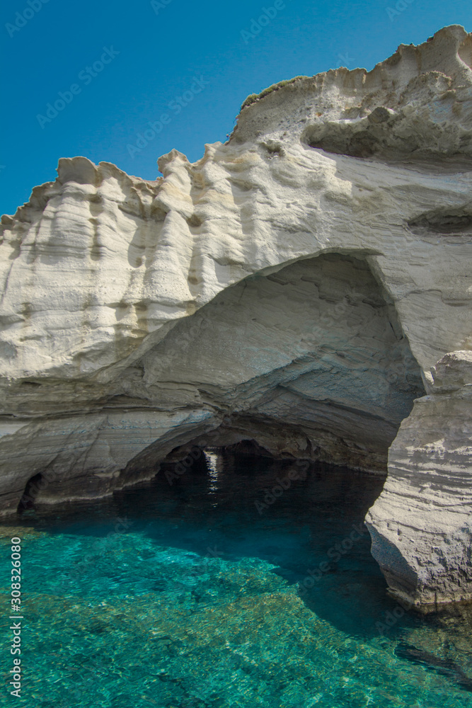 Clear blue water underneath a rock formation in Milos, Greece