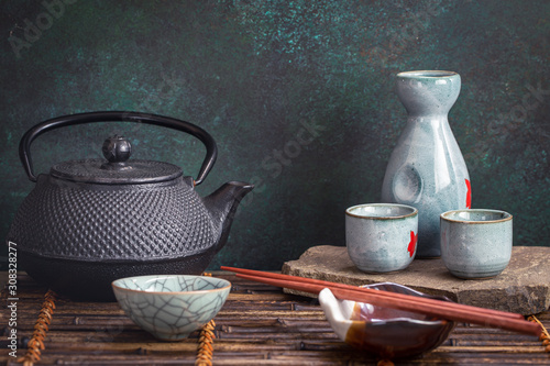 Japanese style tea and sake set on bamboo tray. Selective focus photo