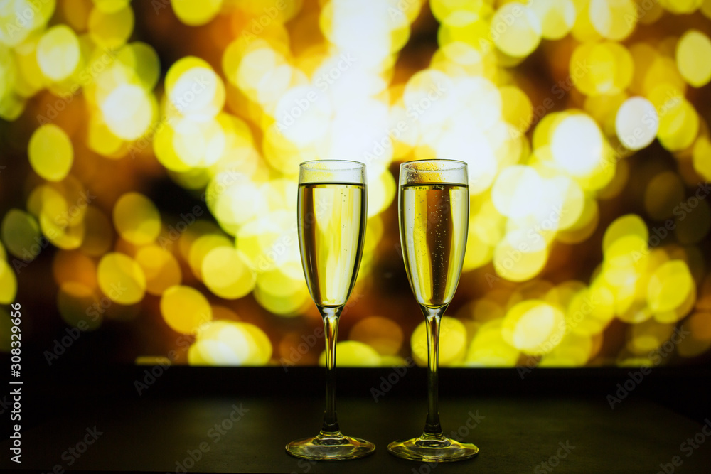 Two glasses of champagne on a bokeh background. Close-up isolated background. Two glasses of champagne on a bokeh background. Close-up isolated background.