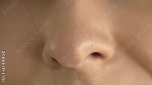 Extreme macro close up of a woman's nose while breathing in fresh air photo