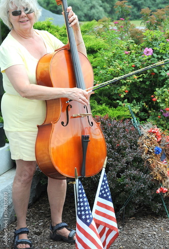 Female cellist with her instrument outdoors. © oscar williams