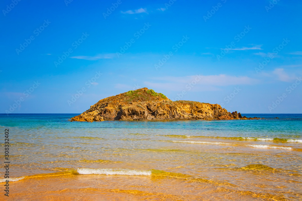 Small island on Chia beach in southern Italy. It is the most beautiful beach in Sardinia. Flamingos live in the wild. It is a long beach with golden sand. Small island on Chia beach in southern Italy. It is the most beautiful beach in Sardinia. Flamingos live in the wild. It is a long beach with golden sand.