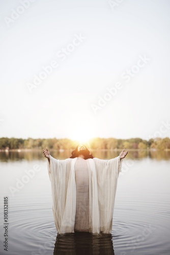 Canvas Print Vertical shot of the Jesus Christ standing in the water with his hands and head