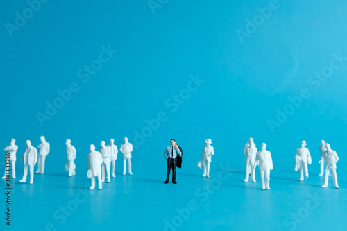 Miniature people concept - a different business worker standout from the crowd