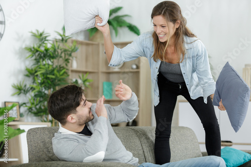 young couple having pillow fight