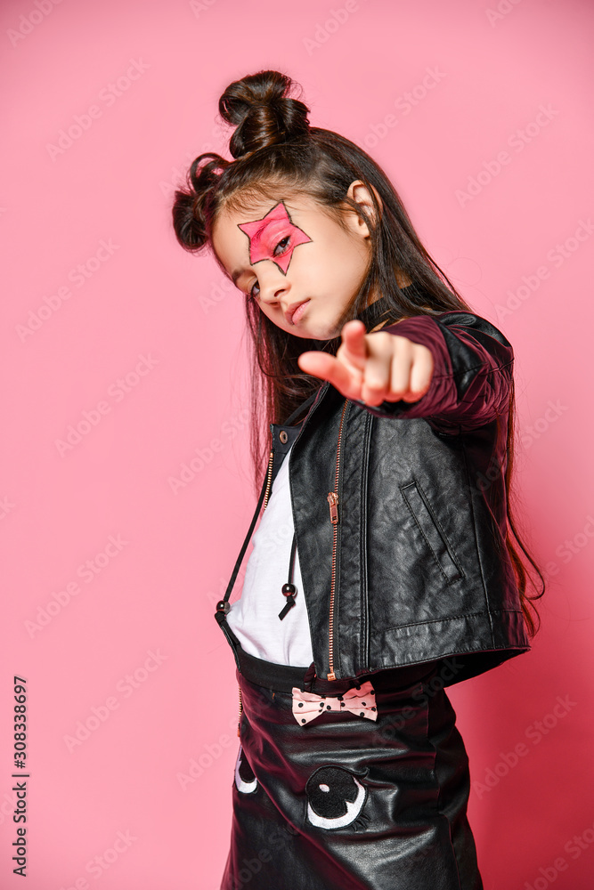 fashionable hipster punk girl - dressed in a leather jacket and skirt,  black knee-highs and a